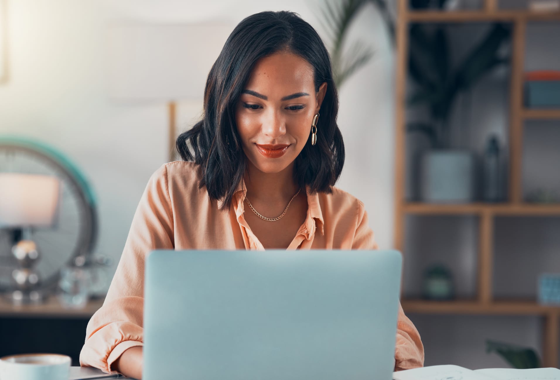 woman sitting at a table with a laptop computer in front of her