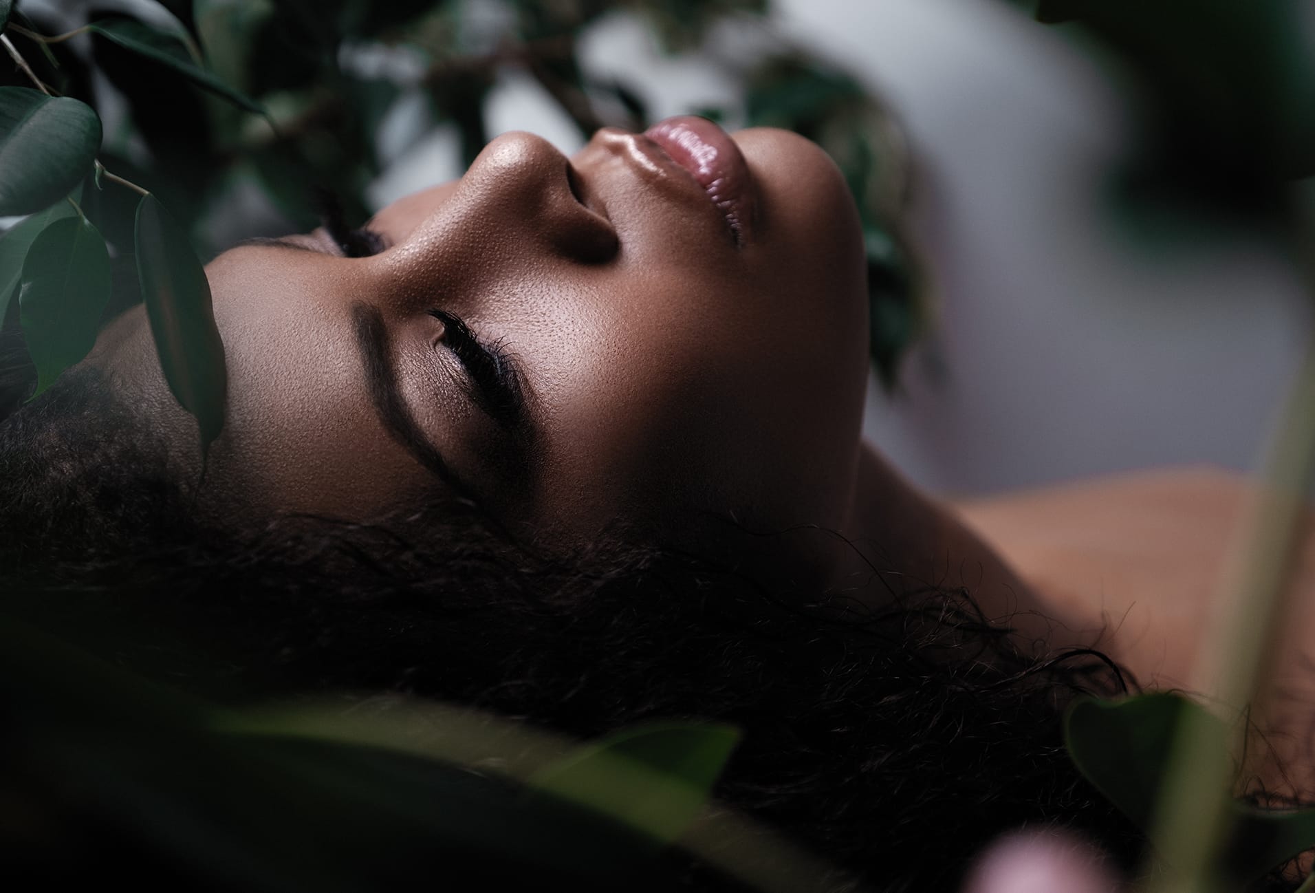 woman laying down near a plant