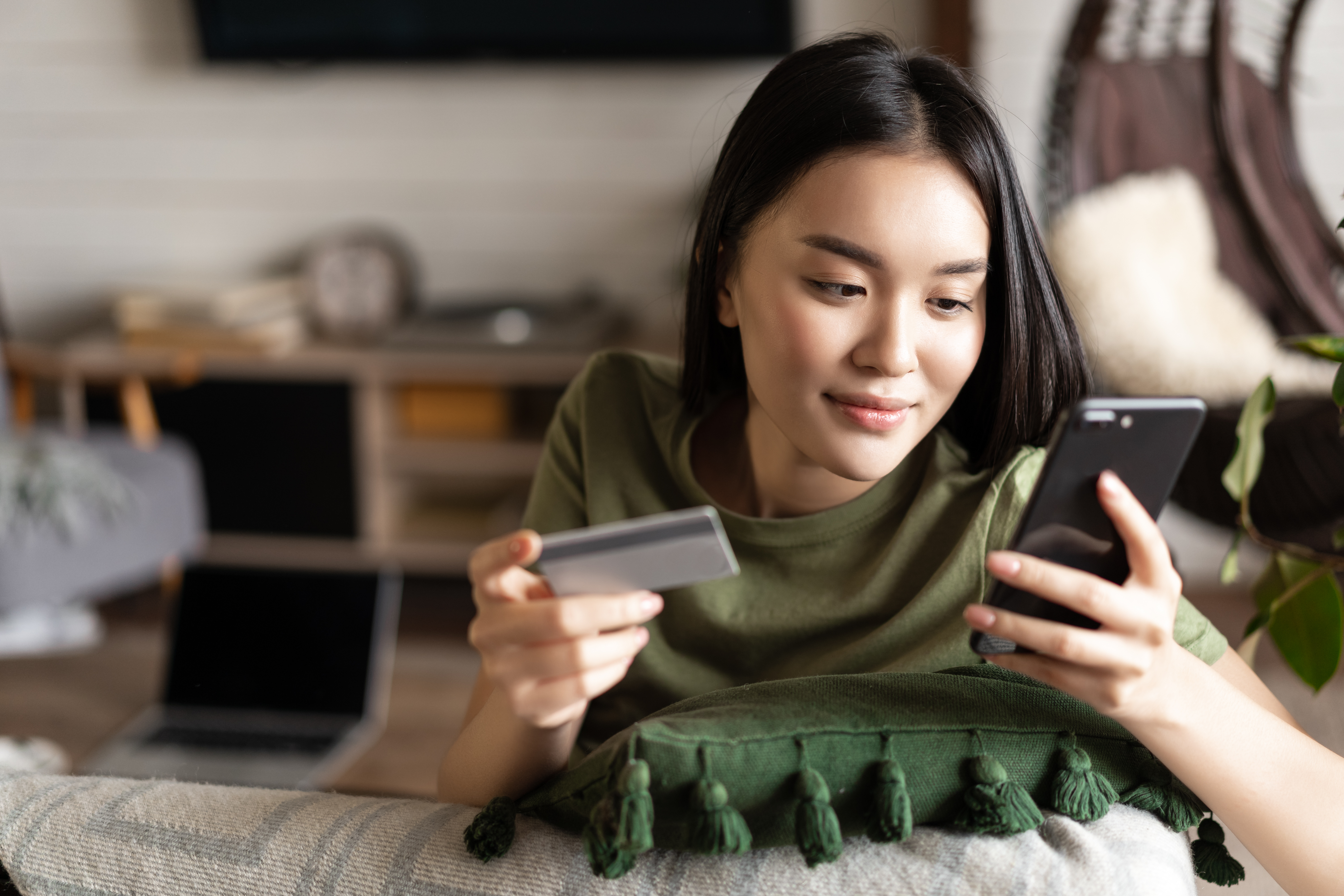 Woman on her phone holding her credit card